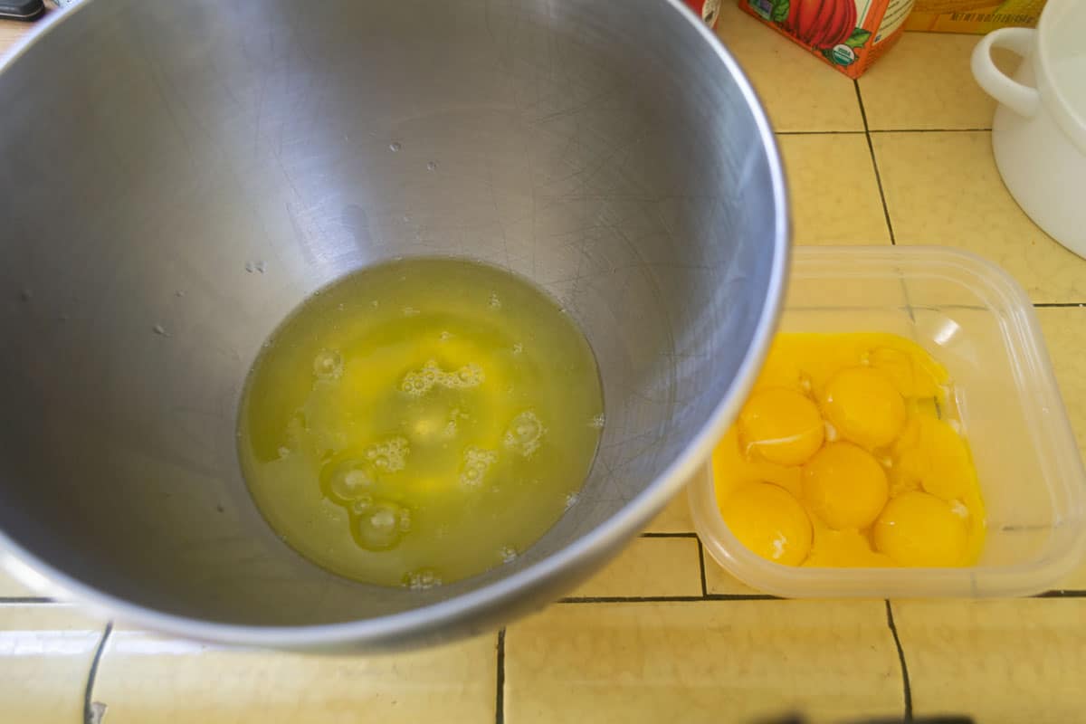 8 eggs are separated into separate bows, with the egg whites in a large mixing bowl and egg yolks in another bowl.