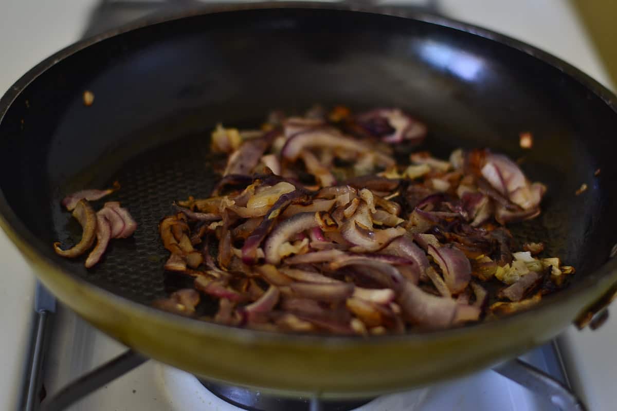  Caramelizing thinly sliced red onions to add to the savory bread pudding mixture.