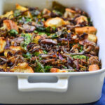 Savory sausage bread pudding casserole in a large baking dish, with sweet italian sausage, cubes of ciabatta bread and caramelized onions.