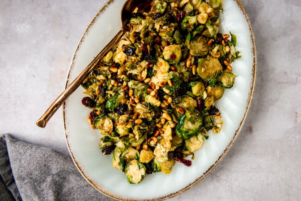Sauteed balsamic brussels sprouts topped with balsamic, toasted pine nuts and dried cranberries.