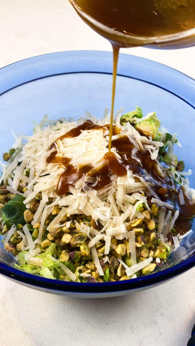 Pour the vinaigrette over the shredded brussels sprouts salad.