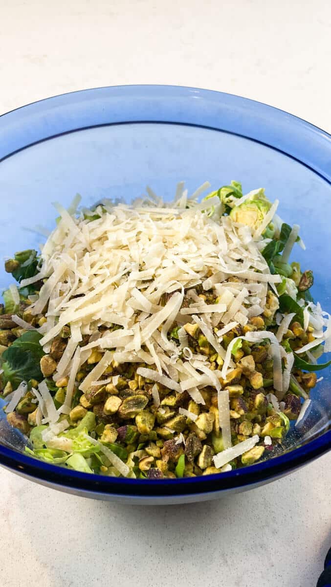 Add grated parmesan cheese to the shaved brussels sprouts along with the grated parmesan cheese.