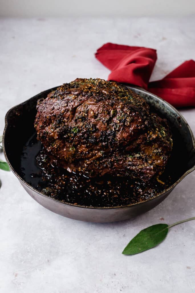 Roasted herb crusted boneless rib roast in a cast iron skillet.