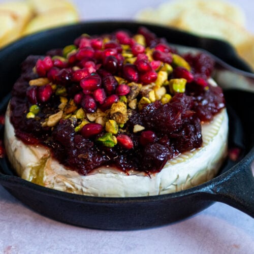 Baked brie topped with cranberry sauce and pistachios.