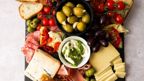 Italian charcuterie board with imported cheeses, meats, fruit and olives.