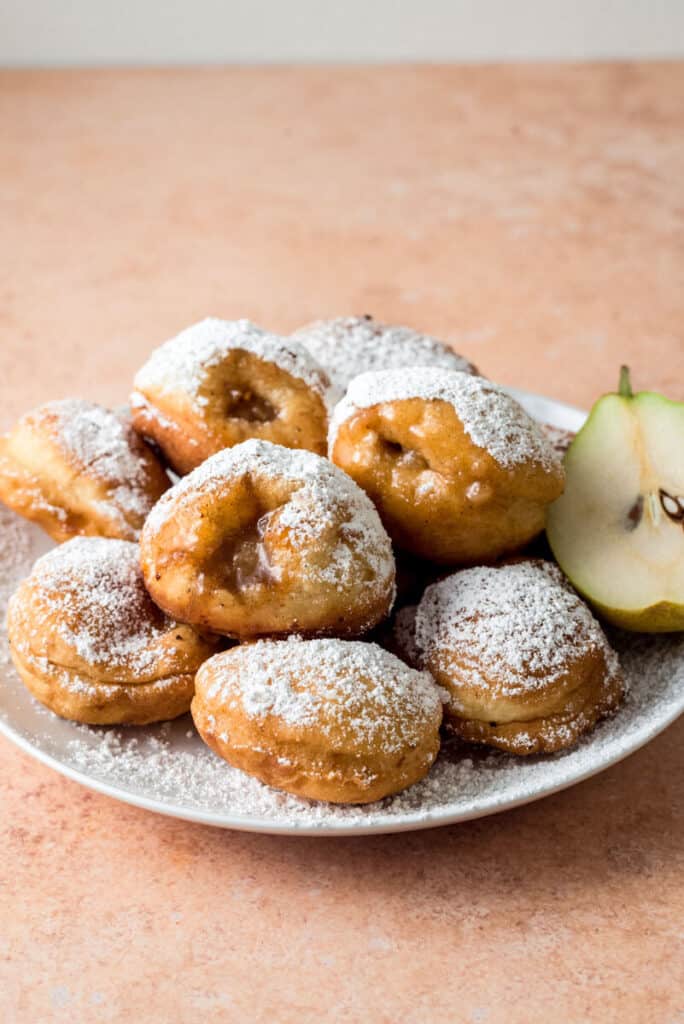 Pear donuts are made with chopped anjou pears that are cooked down with brown sugar and cinnamon until sweet. The pear mixture is tuffed inside donuts and dusted with powdered sugar.