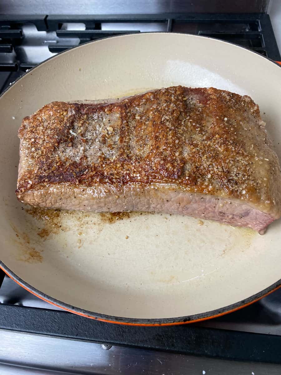 Sear the brisket in the dutch oven on all sides until a deep crust forms.