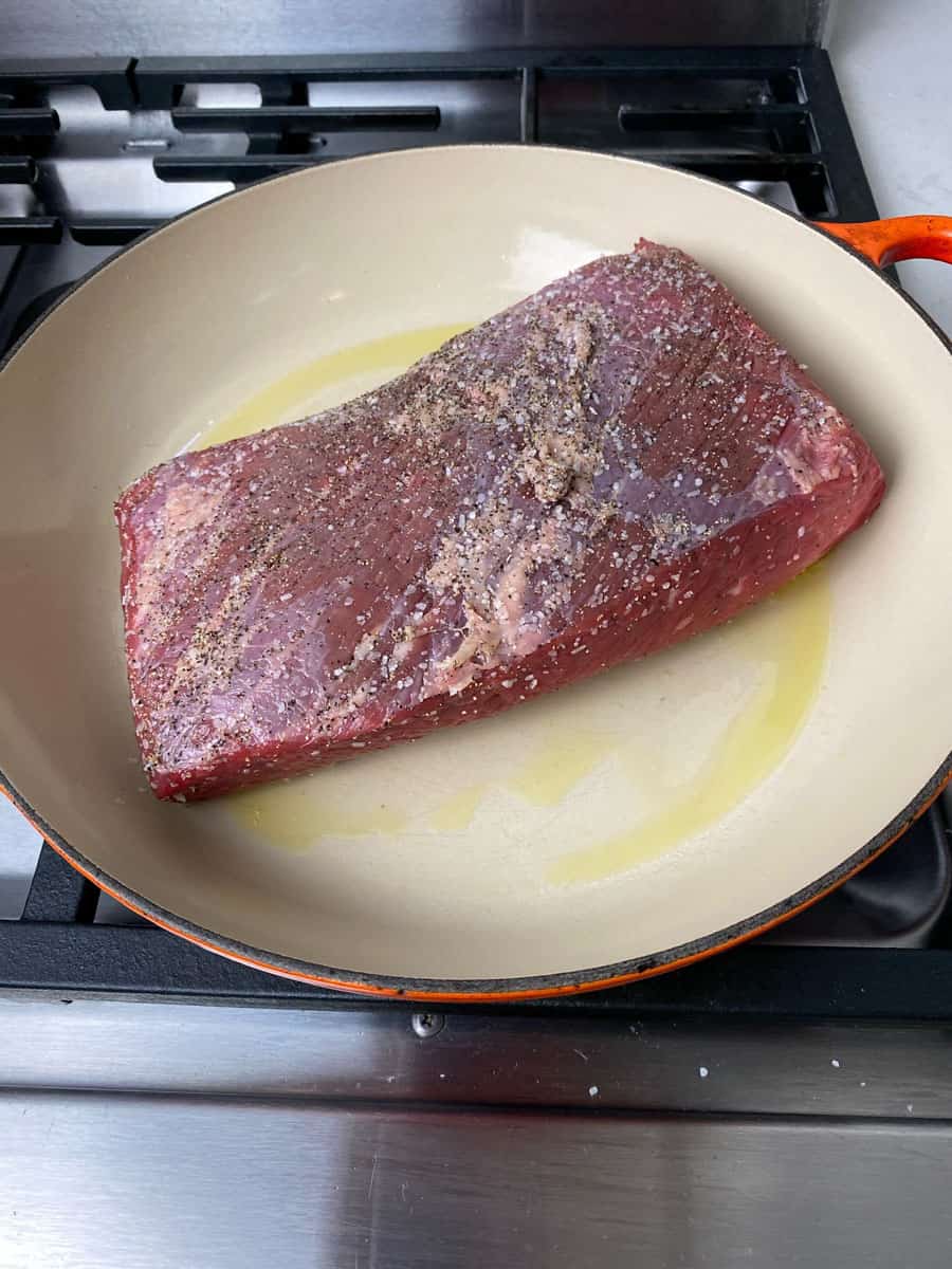 Drizzle a wide dutch oven with oil and sear the brisket.