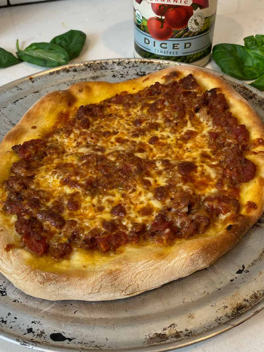 Cook the bolognese pizza until crust is golden and cheese has melted.