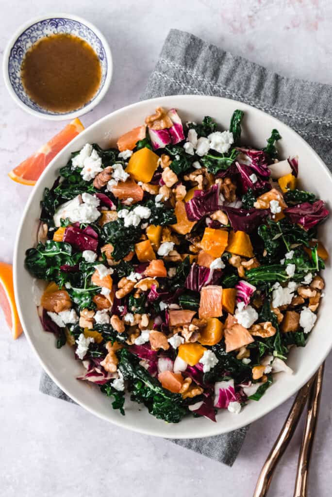 Kale Salad with citrus and roasted beets with a bowl of balsamic vinaigrette.