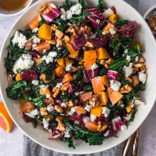 Kale salad with roasted beets and citrus with orange segments off to the side.