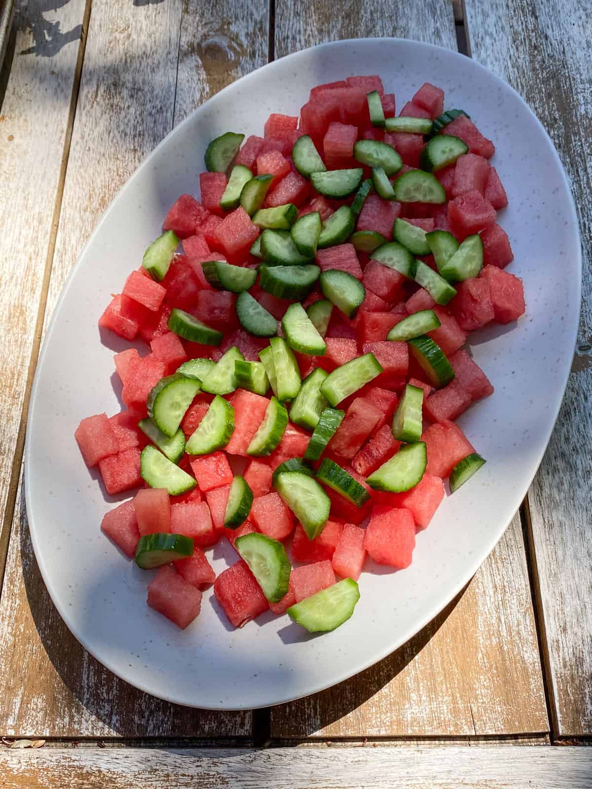 Add cubed fresh watermelon and chopped Persian cucumber to a large platter.