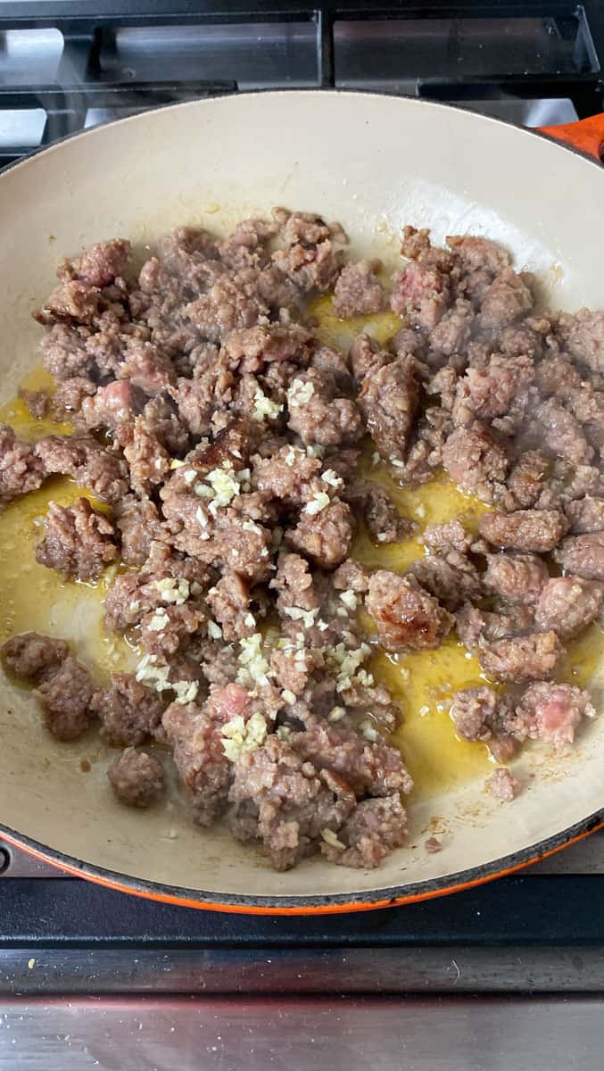 Once the Italian sausage is half way cooked, add the chopped garlic and saute.