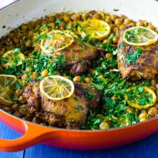 One pot Dutch oven chicken thighs are cooked with rice and chickpeas and seasoned with lemon and cumin.