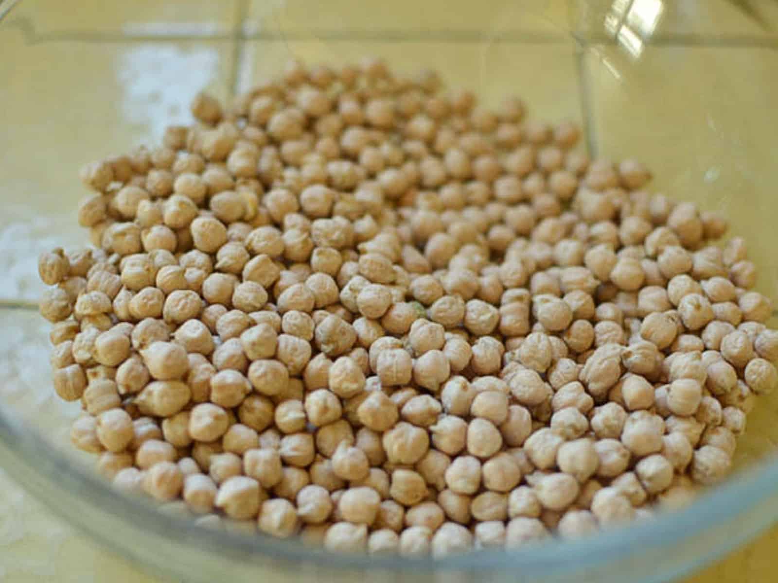 Add dried chickpeas to a large bowl and fill with water, completely covering the chickpeas. 