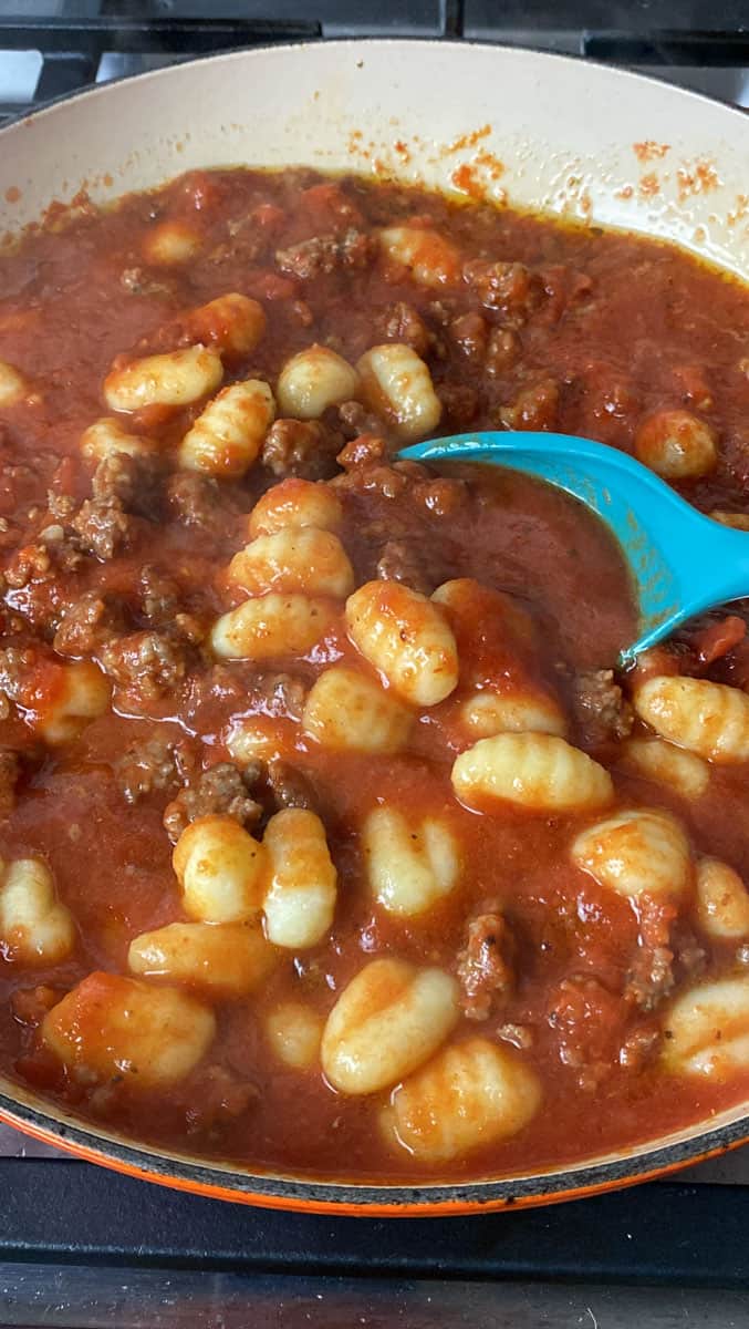 Stir the cooked gnocchi into the sausage and tomato sauce mixture.