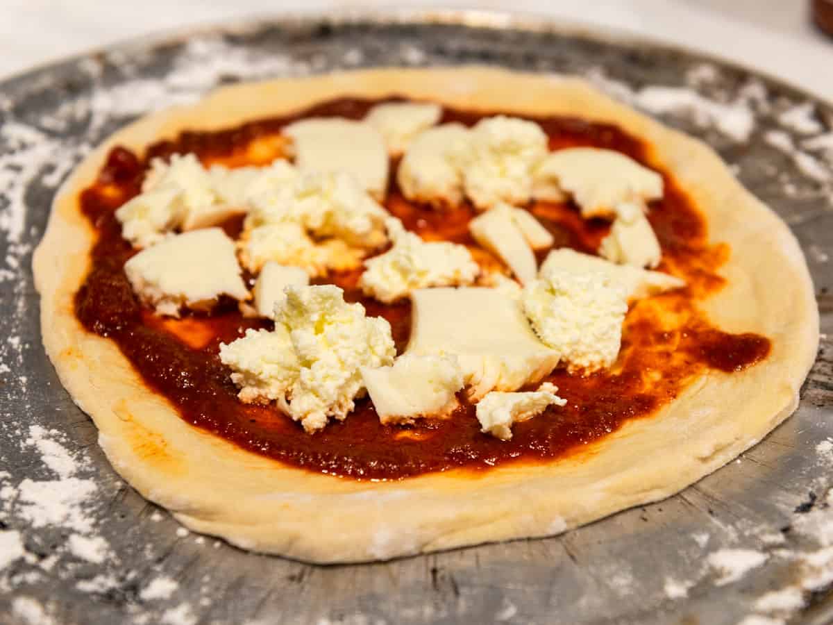 Top the pizza with four cheeses, including mozzarella, pecorino, mozzarella and Parmesan.