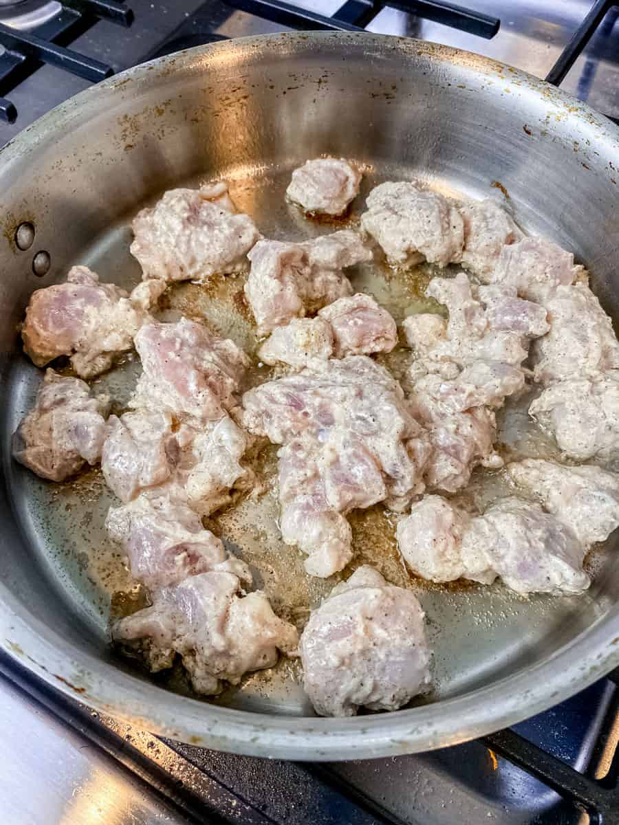 Sear the yogurt marinated chicken pieces in a skillet.