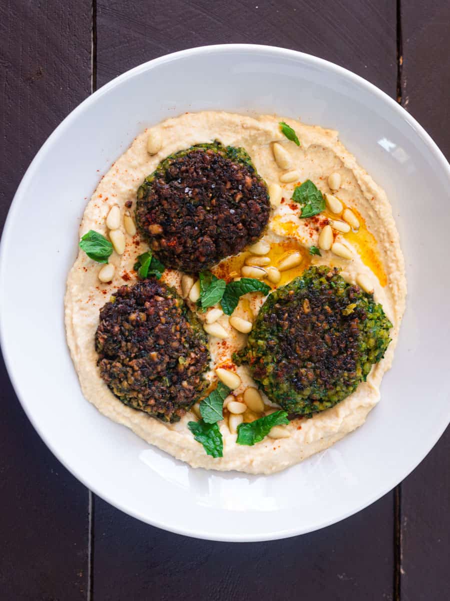 Serve fried green falafel on top of hummus with a drizzle of olive oil.