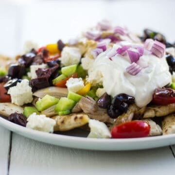 Greek style nachos layered with pita chips, hummus and olives.