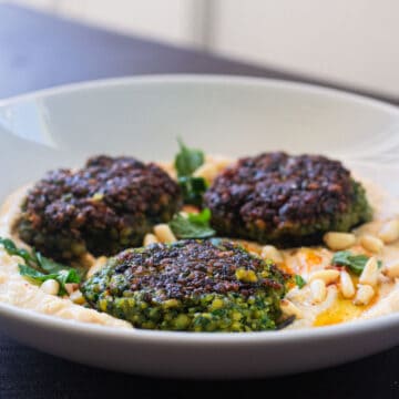 Herb green falafel is served with hummus, olive oil and pine nuts.