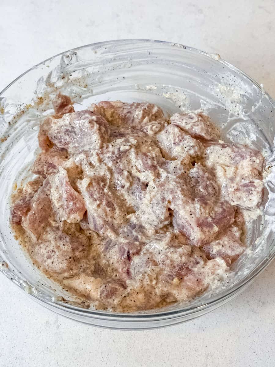 Marinate the chicken thigh pieces in yogurt, garlic and ginger.