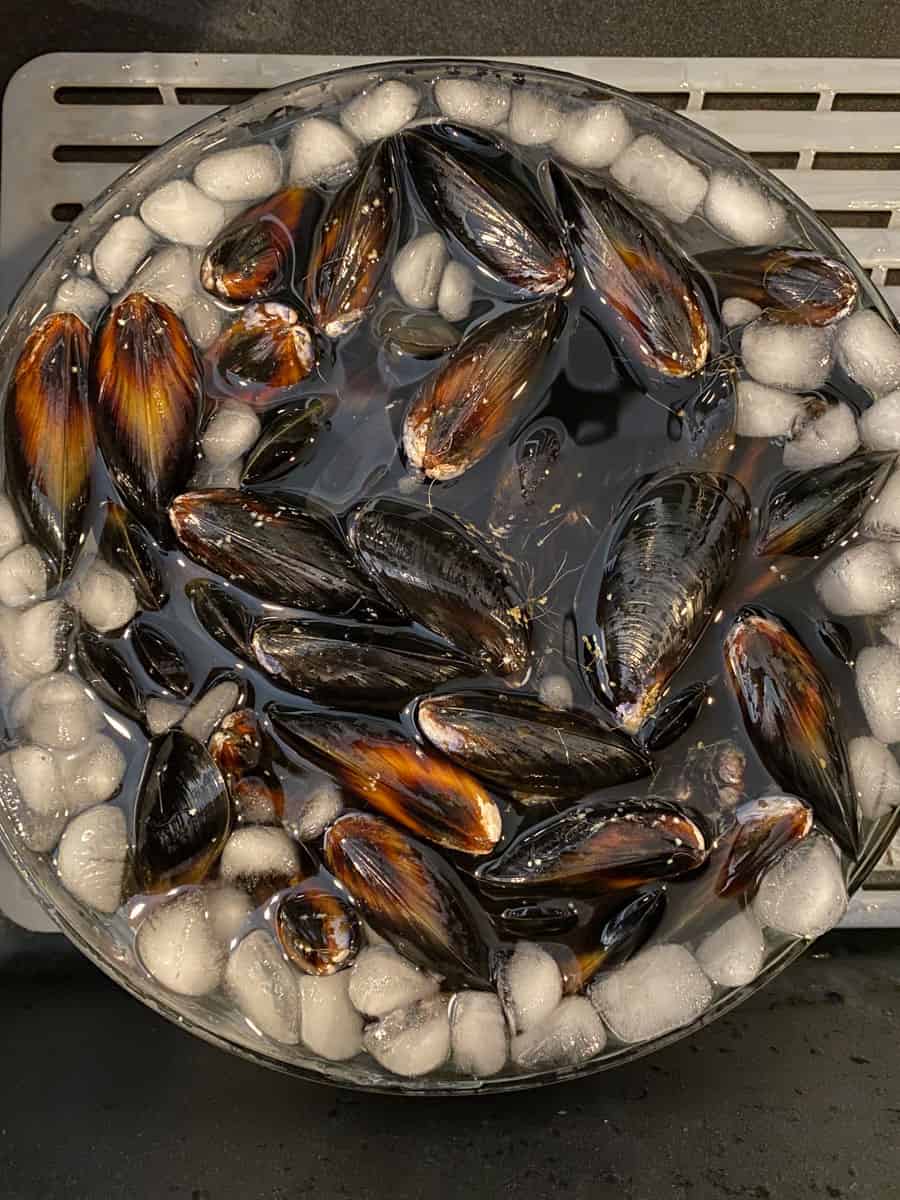 Soak the de-bearded mussels in ice cold water before cooking with them.