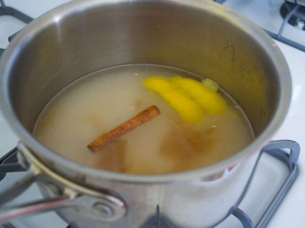 To make the simple syrup, add orange blossom water, a cinnamon stick and lemon peel to the sugar and water mixture.