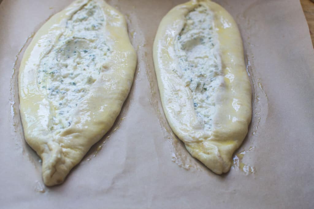 Brush the cheese pide with egg wash before baking.