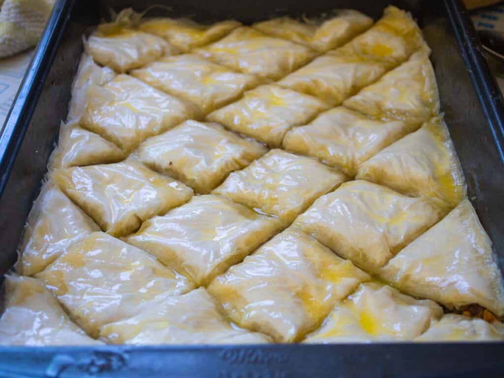 Brush the top of the pistachio baklava with melted butter.