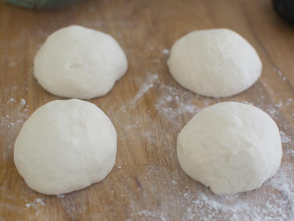 Cut the dough into quarters and roll into a smooth ball.