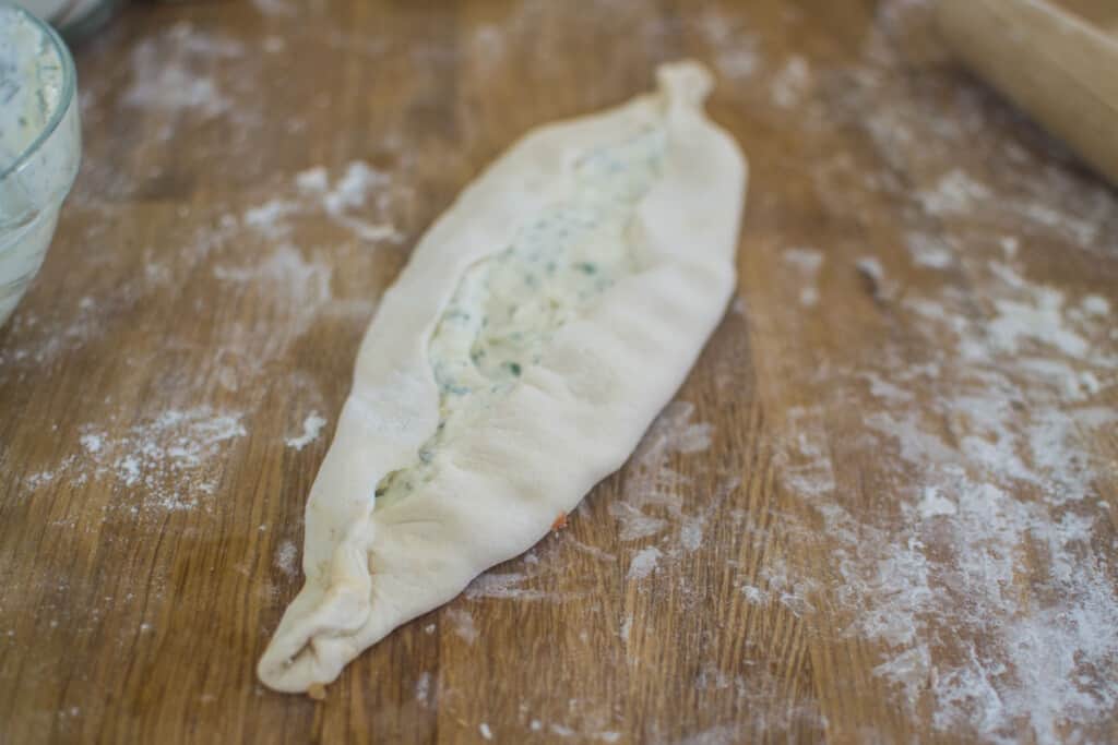 Fold up the sides of the dough to form an oblong shaped pide.