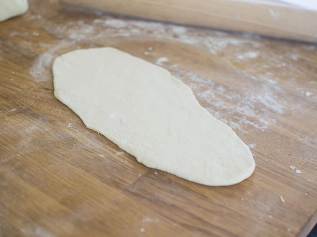 Roll out the dough into a nine inch long flatbread shape.