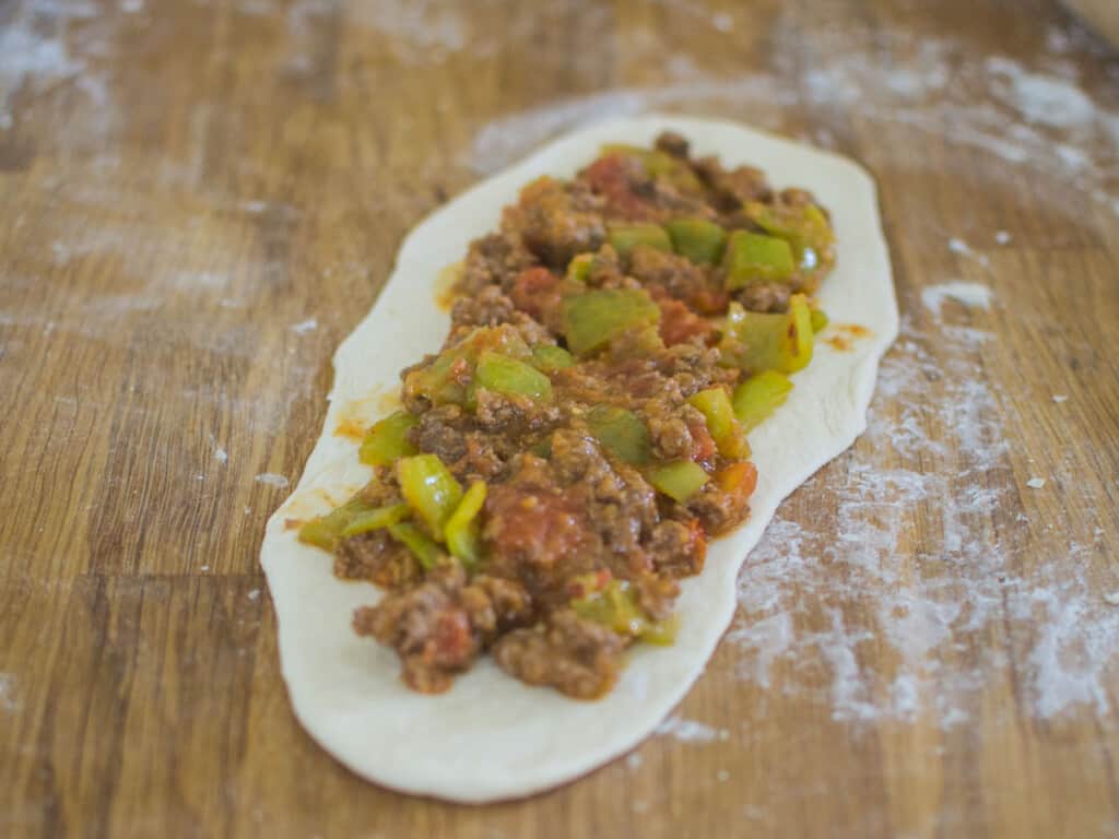 Spread the meat mixture onto the dough for the meat pide.