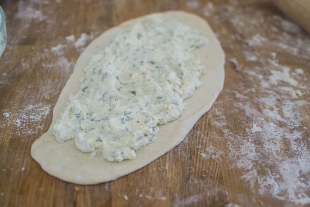 Spread the cheese mixture onto the dough before folding up the sides.