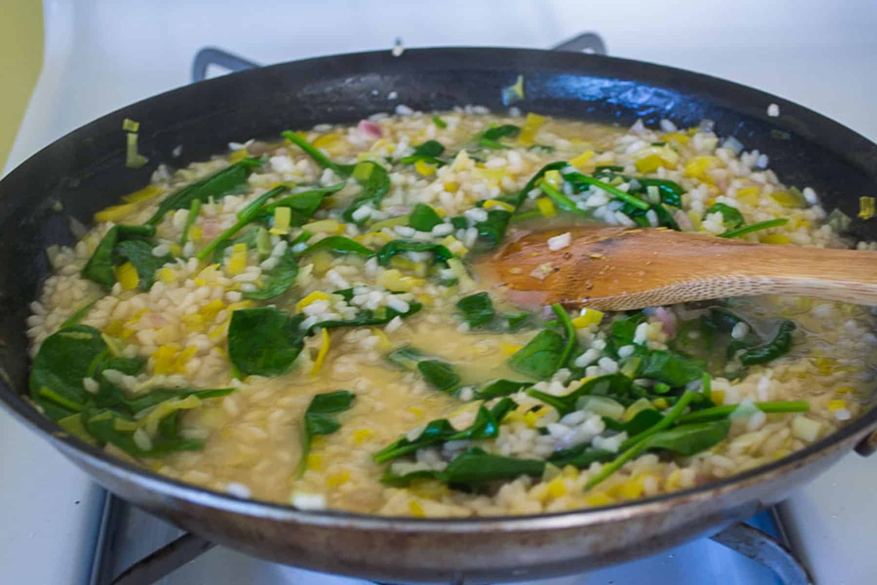 Add fresh baby spinach to the risotto and stir until just wilted.
