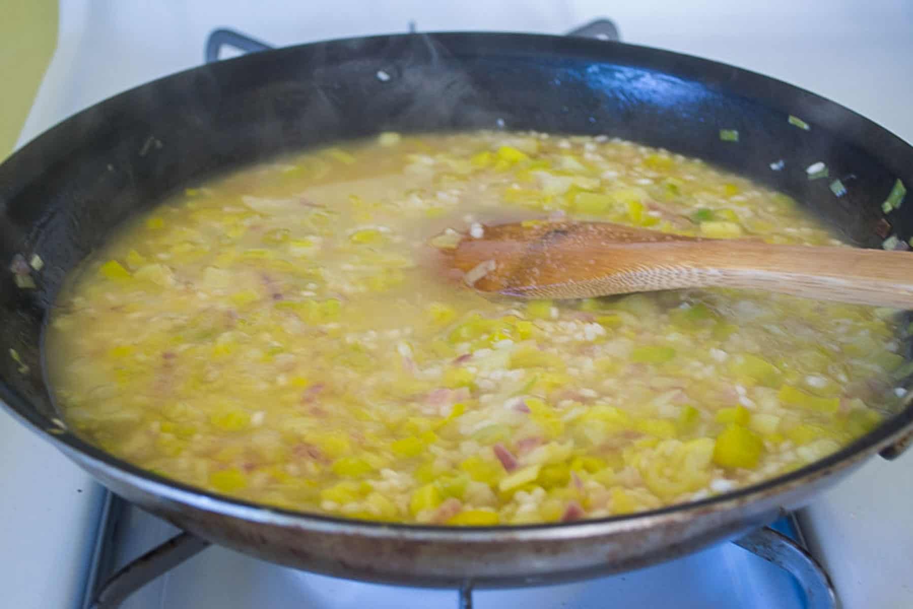 Add vegetable stock to risotto and simmer until stock begins to reduce.