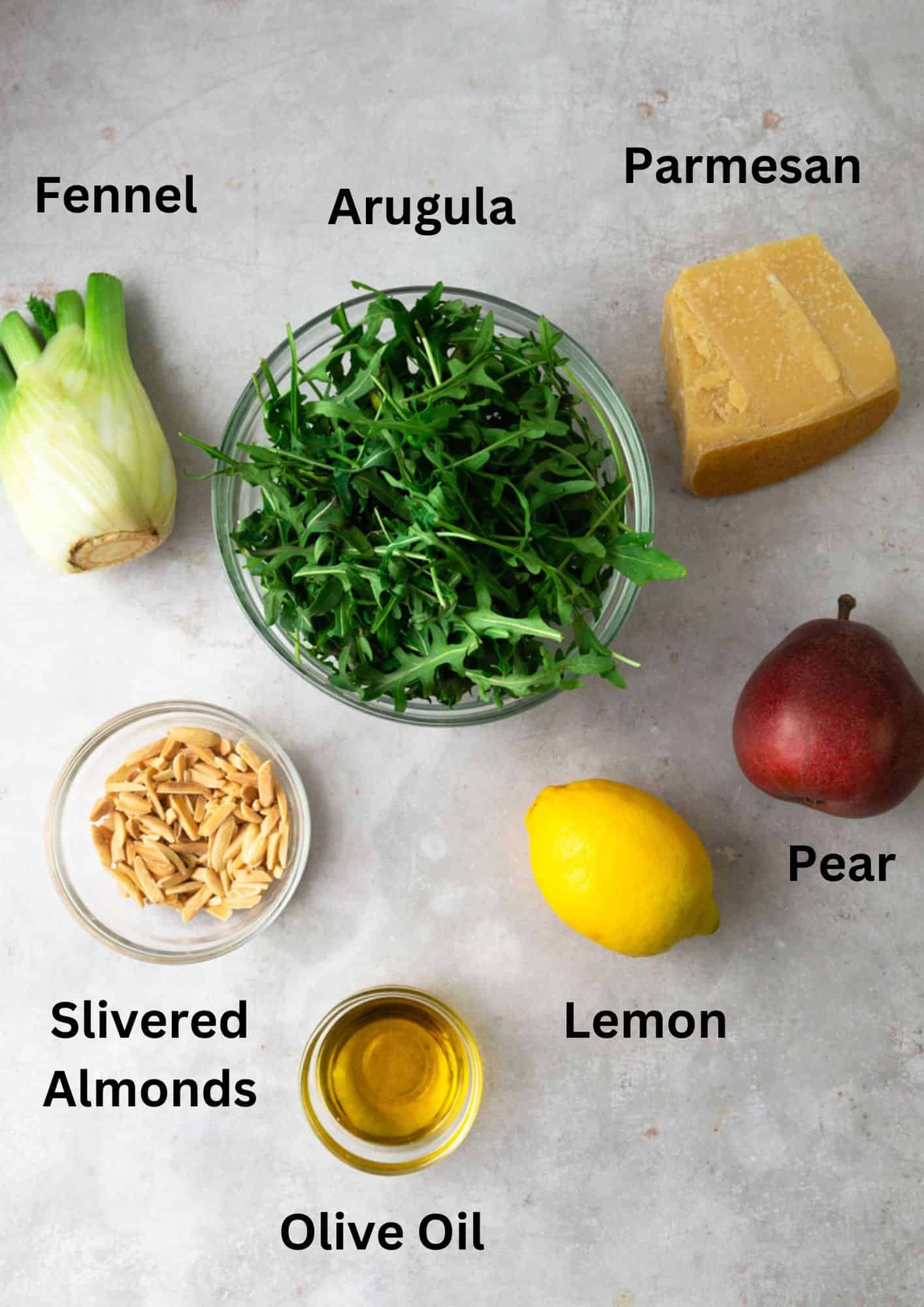 Ingredients for arugula and pear salad, including fennel and slivered almonds.