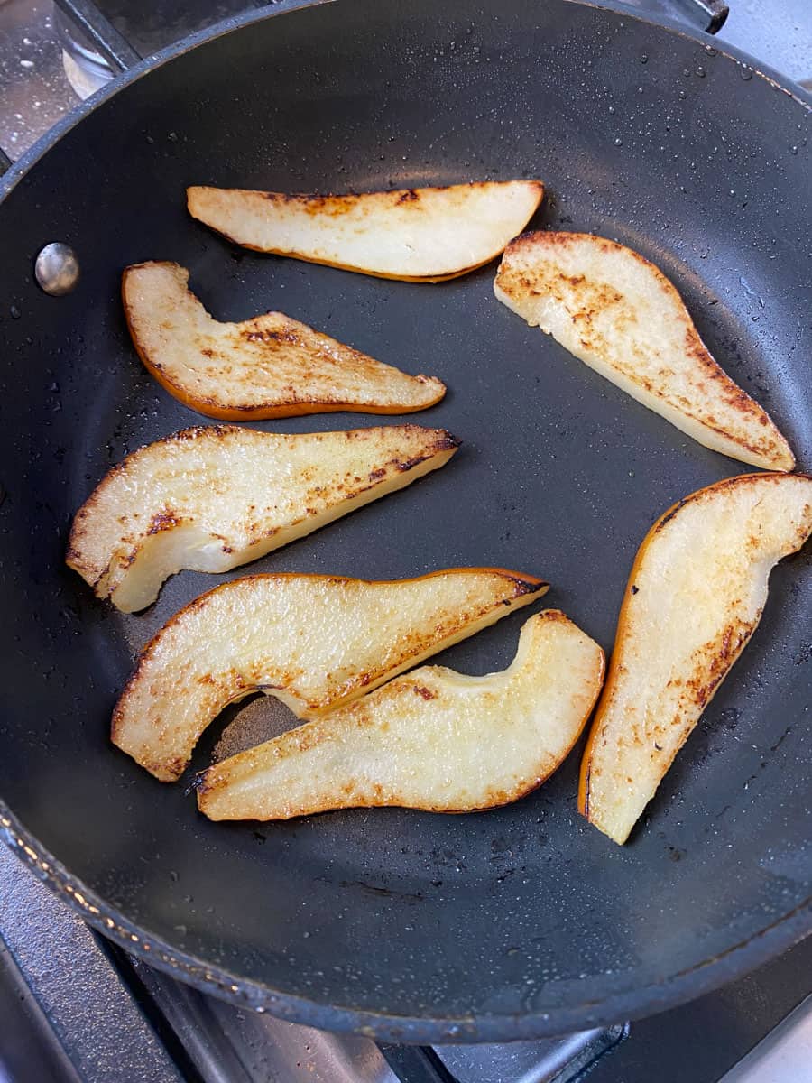 Cook the sliced pears in a skillet until edges are caramelized.