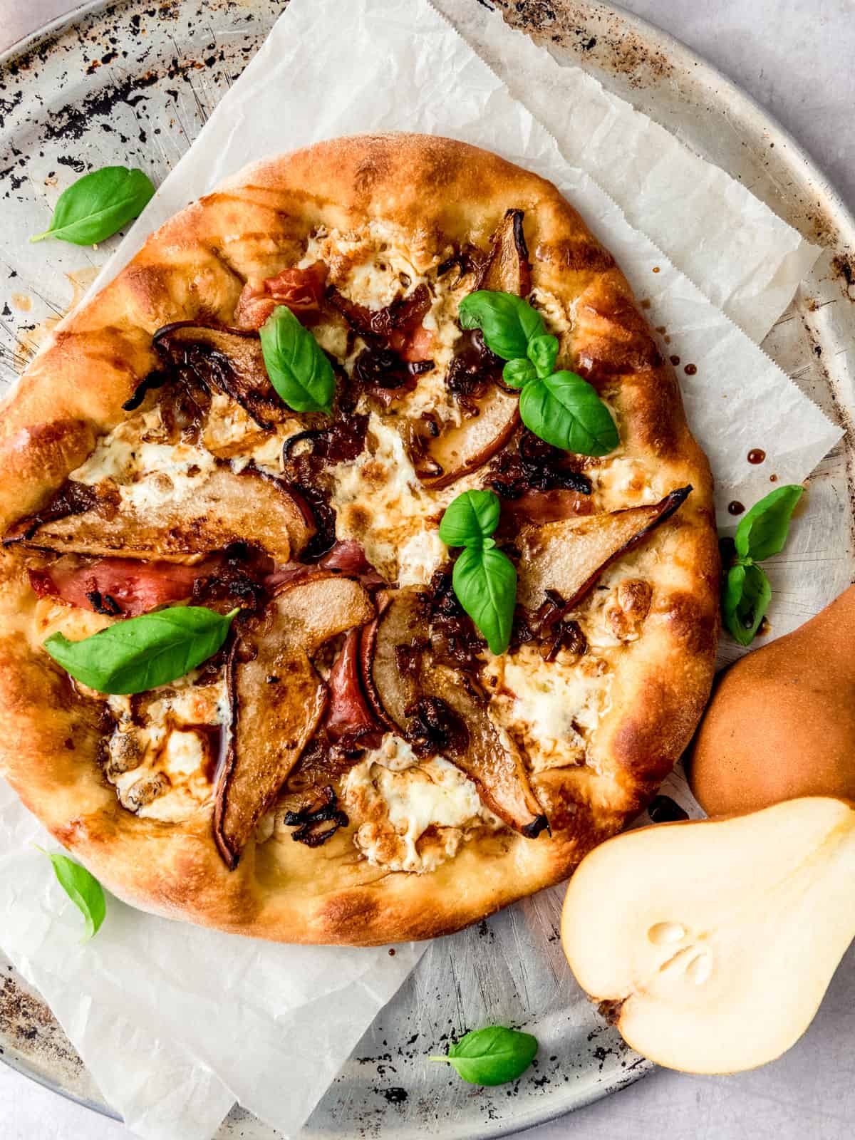 Caramelized pear and prosciutto pizza with mozzarella and drizzled with aged balsamic vinegar.