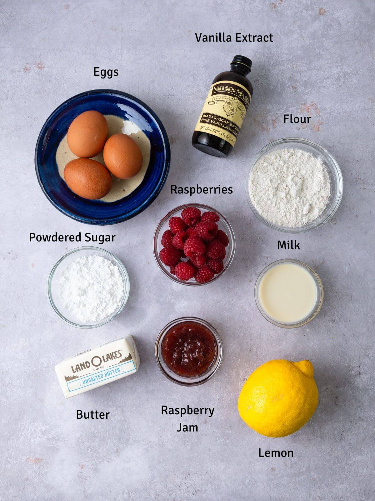 Ingredients for raspberry Dutch baby including fresh lemon and vanilla extract.