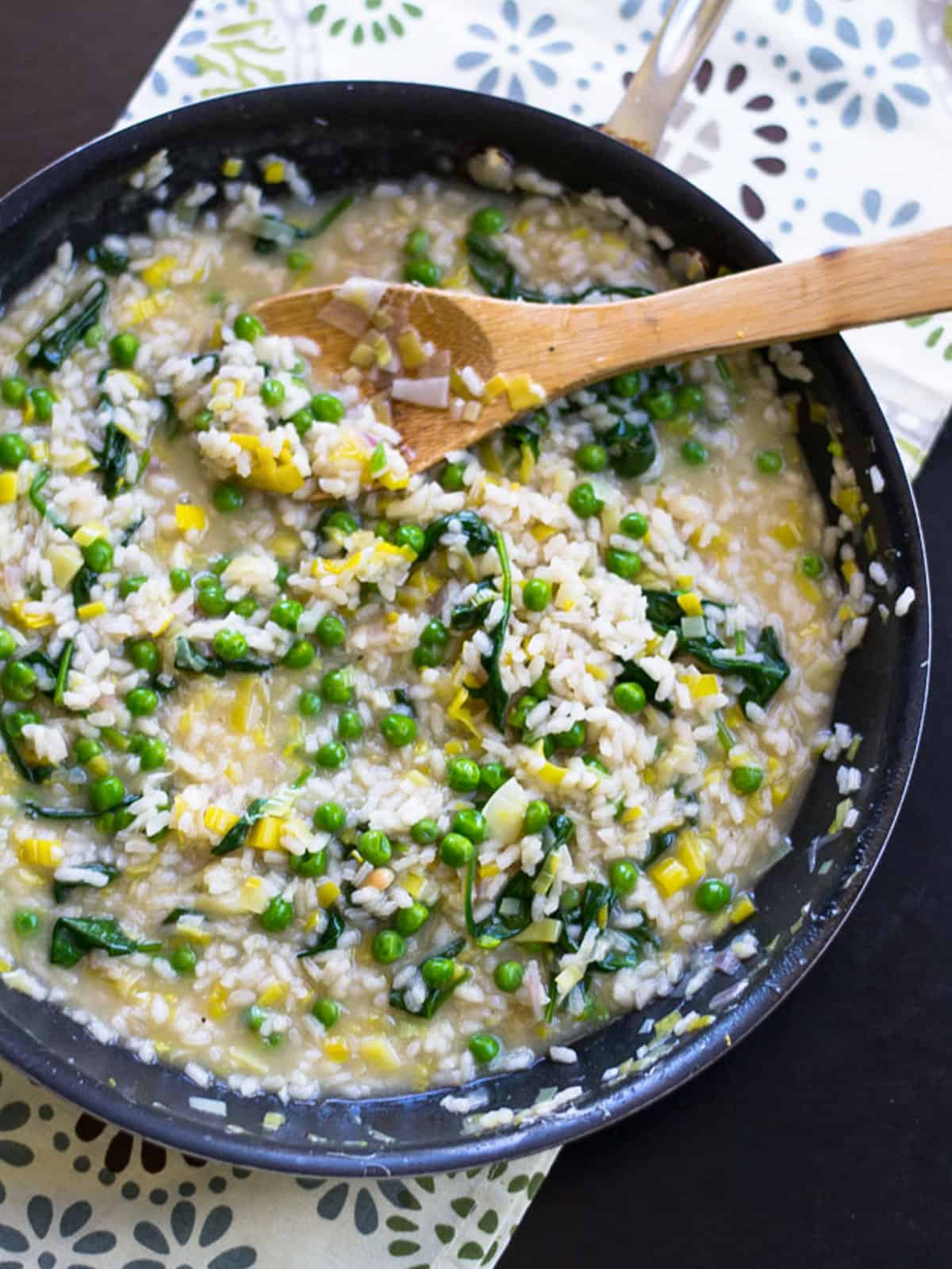 Spinach risotto with sautéed leeks and peas.