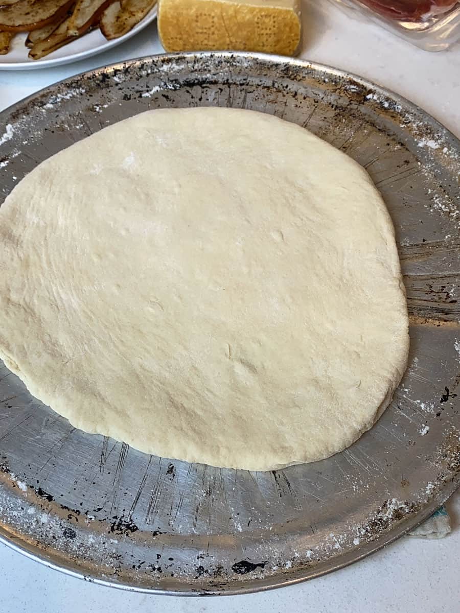 Stretch out the pizza on a lightly floured surface into an even 10 inch circle.