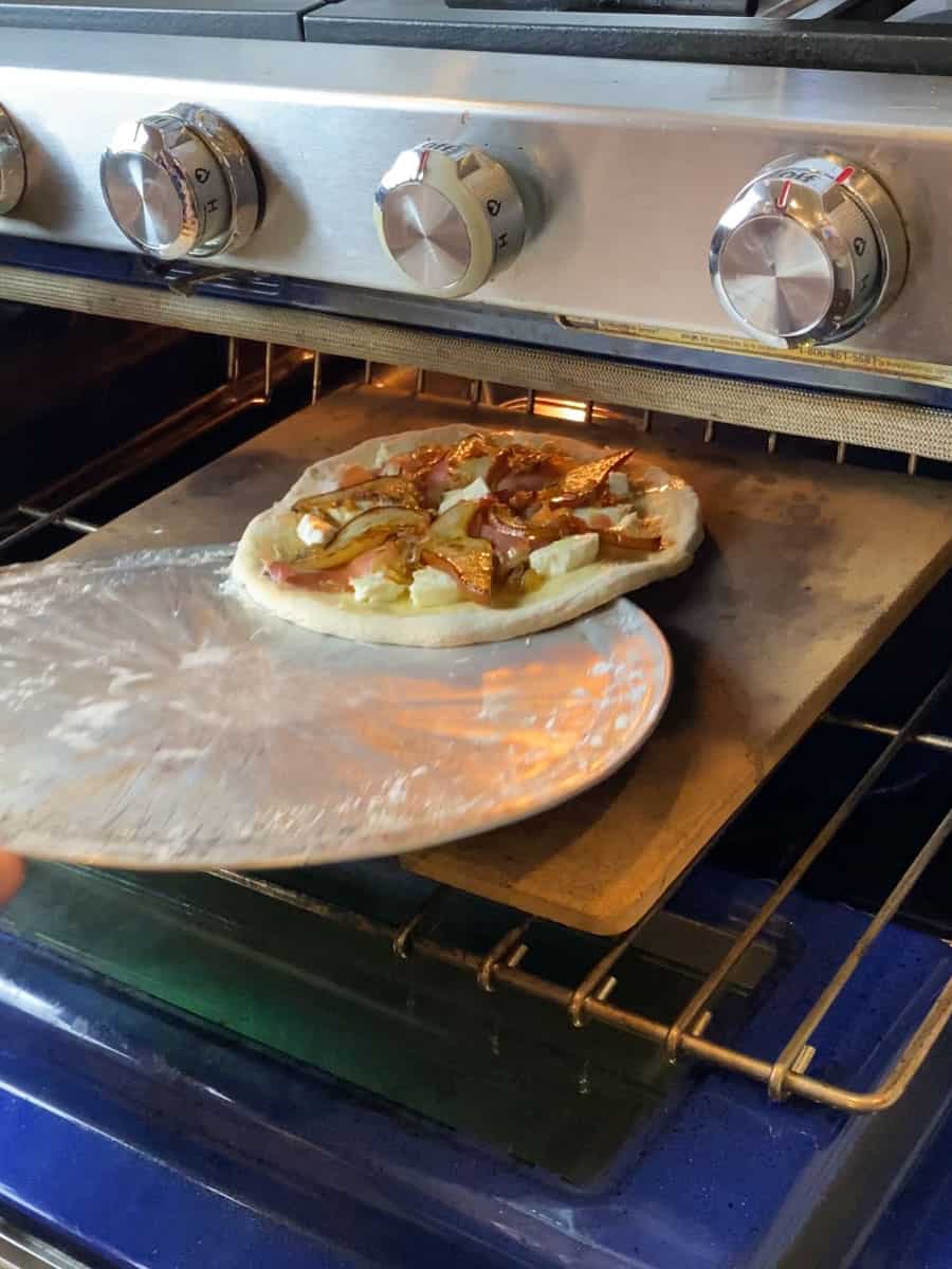 Transfer the pear pizza onto a hot pizza stone in a pre-heated oven.