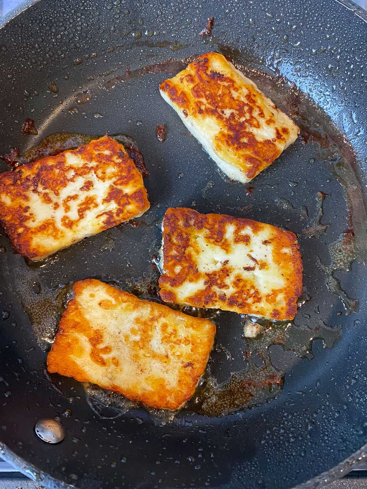 Fry slices of halloumi cheese until golden on both sides.