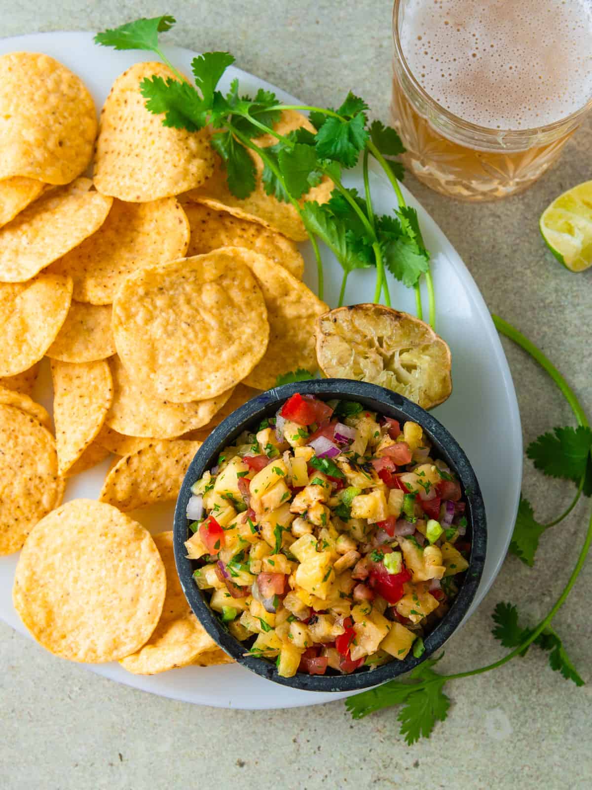 Serve grilled pineapple pico de gallo with tortilla chips and grilled lime.