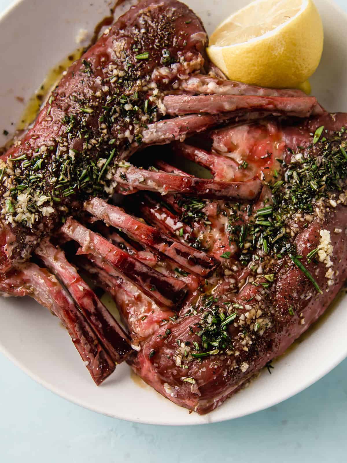 Marinate the rack of lamb with herbs and garlic.