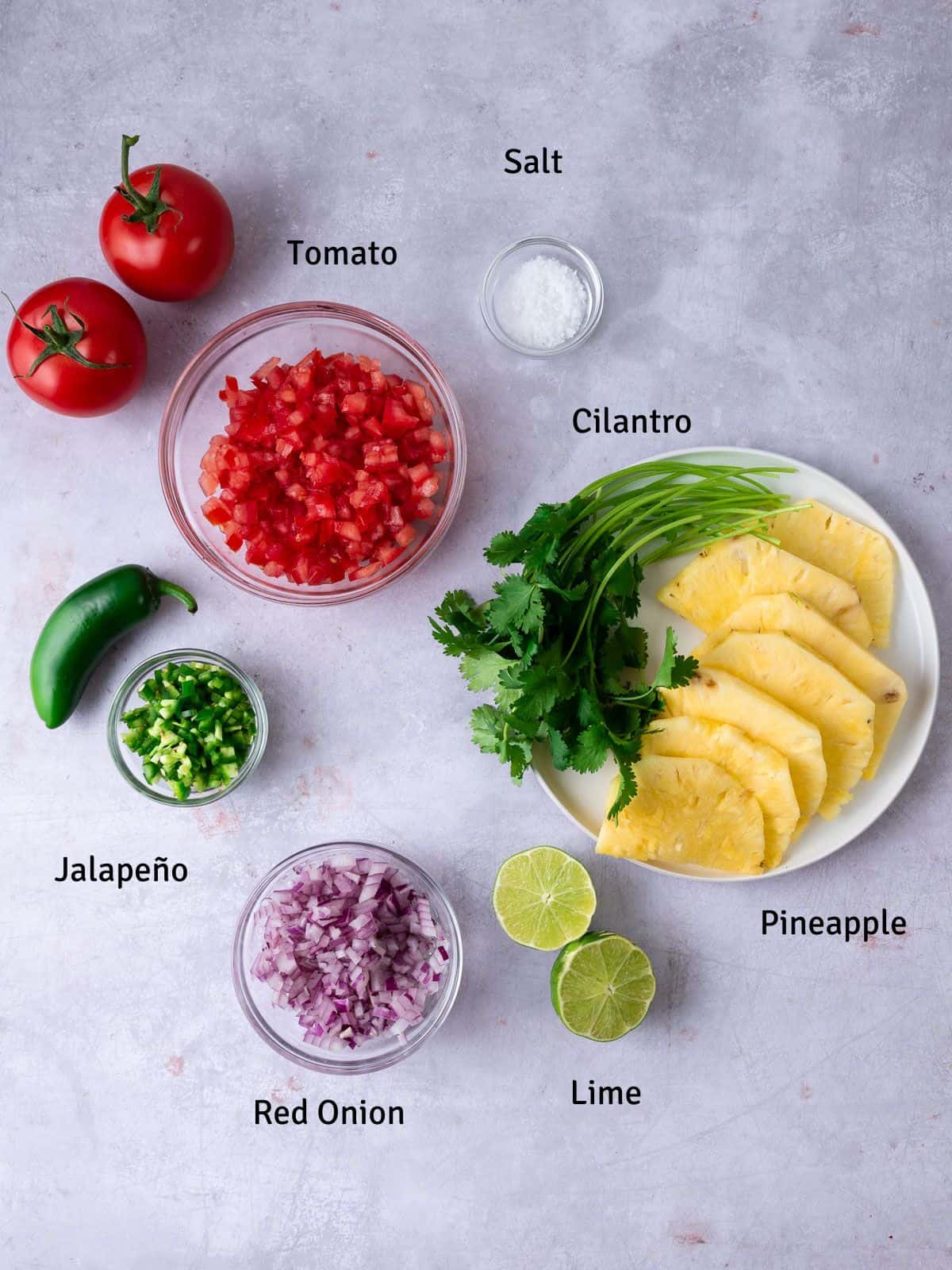 Ingredients for pineapple pico de gallo with tomato and lime.