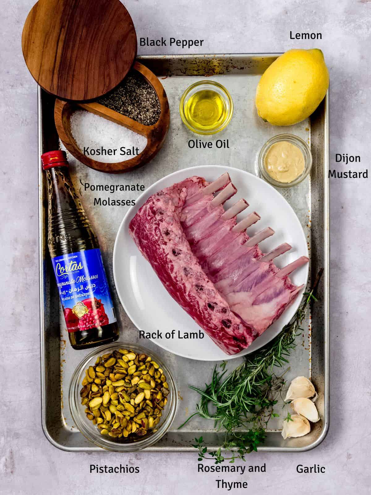 Ingredients for pistachio crusted lamb, including fresh herbs and lemon.