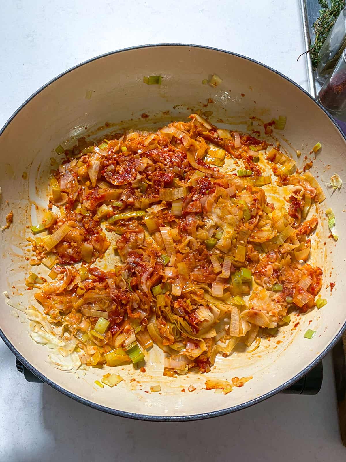 Add tomato paste to the sautéed leeks and fennel and saute the tomato paste into the oil and butter.